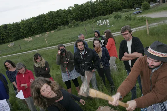 Meeting in Friland - participant swinging an axe